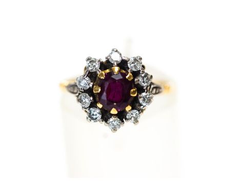 A garnet and diamond cluster ring, the cushion shaped stone enclosed by ten old cut diamonds totalling approximately 0.35 car