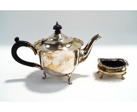 A silver teapot, by Mappin & Webb, Sheffield 1904; with a silver salt with pierced cape rim, blue glass liner; 340 g (10.9 tr