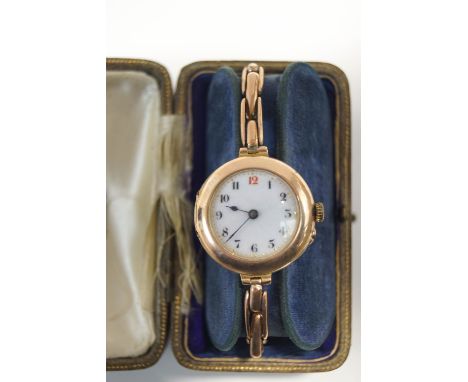 A 9 carat gold lady's wristwatch, with an enamel dial, on an expanding baton link bracelet, 21 g gross inclusive of movement,
