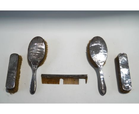 A pair of silver dressing table hair brushes; pair of clothes brushes; and a comb