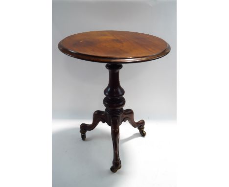 A Victorian and later mahogany tripod table, on scroll legs raised on brass castors, 65cm high x 54cm diameter