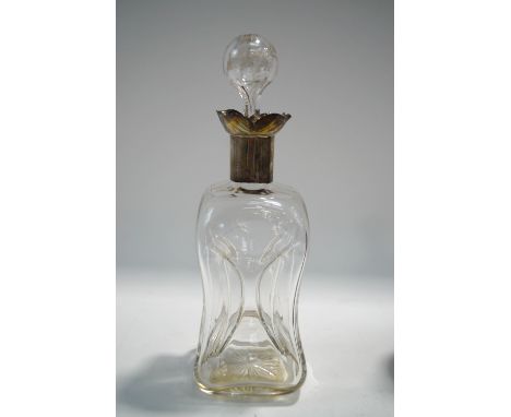 A glass decanter and stopper of pinch-wasted form, with hallmarked silver collar, 29cm high