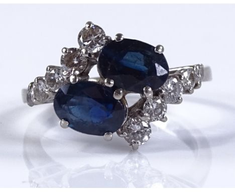 An 18ct white gold sapphire and diamond crossover ring, oval-cut sapphires approx 0.9ct each, setting height 13.4mm, size N, 