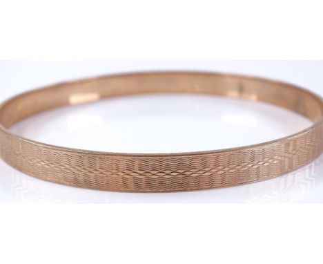 A 9ct rose gold engine turned bangle, internal diameter 75.2mm, 28.5g