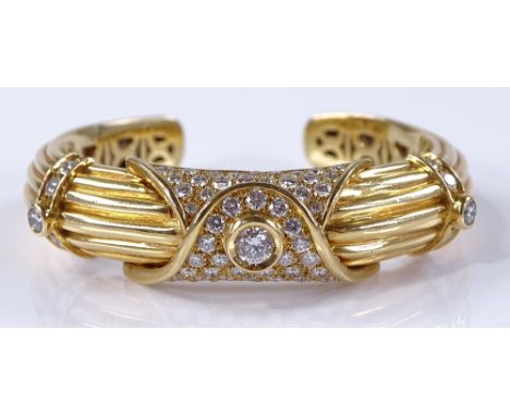 An 18ct gold diamond encrusted hinged bangle, circa 1960s, total diamond content over 3ct, extended internal diameter 59mm, b