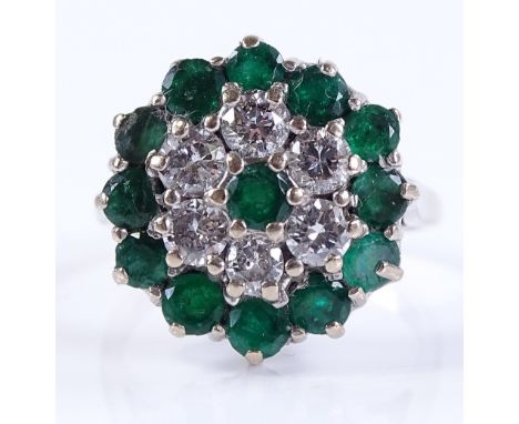 An 18ct white gold emerald and diamond cluster ring, hallmarks London 1972, total diamond content approx 0.75ct, setting heig