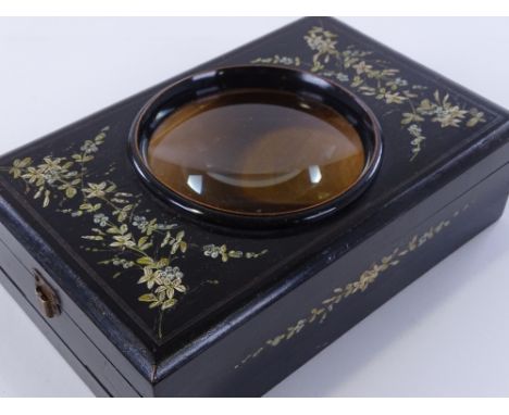 A 19th century ebonised postcard magnifying viewer, with hand painted floral decoration and magnifying lens, length 22cm