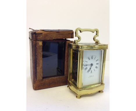 A brass and glass cased carriage clock with white enamel dial, inscribed Brennon, Cork & Paris in original leather case with 