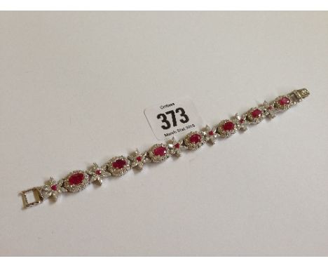 A silver and ruby set bracelet.