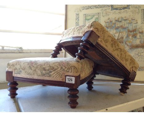 A pair of upholstered oak footstools on bobbin turned supports.