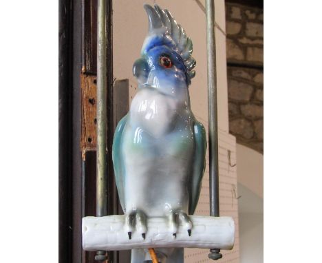 Continental porcelain ceiling light in the form of a parakeet perched on a branch suspended within metal framework (for re-wi