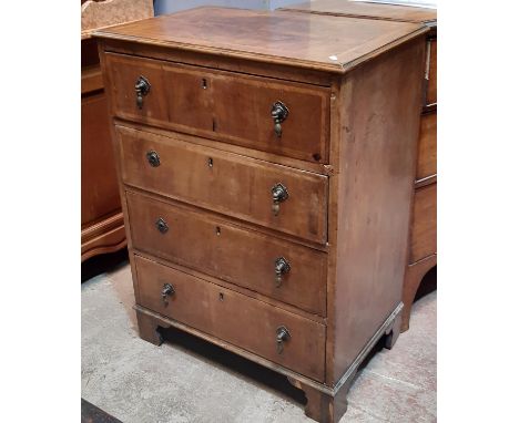 A small walnut veneered chest of four long graduated drawers with quarter panel top, herring bone inlay, set on bracket suppo