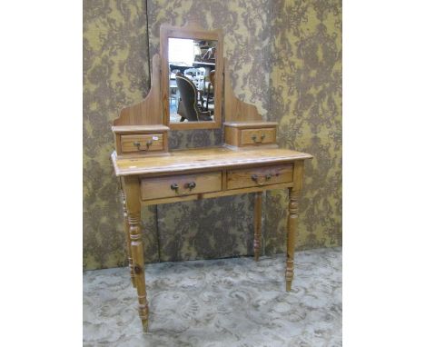 A stripped pine side table with raised central swing mirror over trinket drawers, two frieze drawers raised on ring turned an