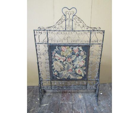 19th century iron work fire screen with scrolled detail supporting a hand worked tapestry panel to the centre, 120cm high x 8