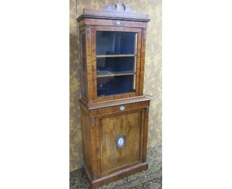 A matched pair of 19th century French walnut pier cabinets, the lower section enclosed by panelled doors, the upper section b