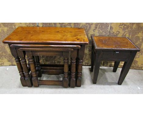 A nest of three old English oak occasional tables on turned supports 61cm wide and smaller, together with a small oak stool w
