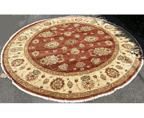 A circular Zeigler carpet with a central brown circular panel with an all over floral pattern, and a cream running floral bor