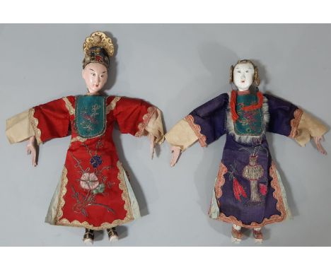 Two early 20th century Chinese 'Opera' dolls, with long puppet-style hands, wearing traditional embroidered robes and boat st