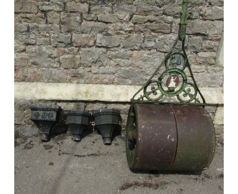 An antique cast iron garden roller, with oval seated Britannia plaque, 58cm (full width) together with three reclaimed cast i