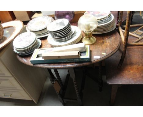 An oak gate leg table raised on barley twist supports