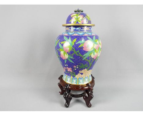 A large Chinese cloisonné enamel vase and cover decorated with branches of peach, ruyi head border to the shoulder and surrou