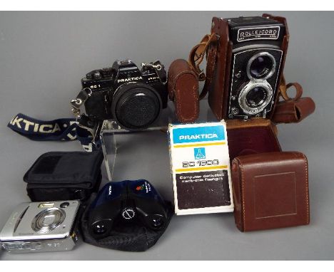 Photography - A vintage Rolleicord camera with leather case, a Praktica BC1, a modern Fujifilm digital camera and a Prinz sli