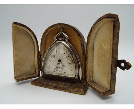 A small Art Deco silver purse or desk watch/ clock in the style of a horse’s stirrup, the case with folding frame for use whe