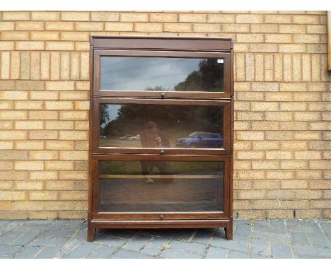 A Gunn three tier sectional bookcase, approximately 123 cm x 87 cm x 31 cm.Condition - The dark coloured glass is in good con