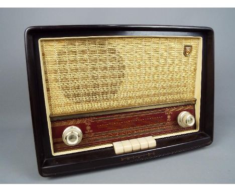 A 1950's Bakelite radio set by Phillips, Type B3G63A, dark brown Bakelite case with cream and gold woven material grille, inp