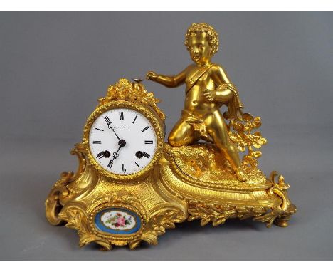 A good, floral and rococo-styled ormolu French mantel clock, the case having the figure of a young boy, inset porcelain panel