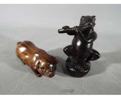 A vintage Japanese dark wood Netsuke depicting a frog type creature possibly playing aflute, signed and a vintage dark wood N