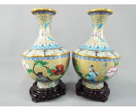 A pair of Chinese cloisonné vases decorated with flowers, birds and insects on an ivory ground, stylised lotus scroll to the 