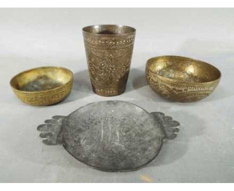Four middle eastern metal dishes, comprising four bowls and a cup having chased decoration. [4]