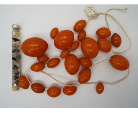 A graduated amber bead necklace, in need of re-stringing, largest bead 30 mm x 22 mm, smallest 14 mm x 9 mm, 64 grams all in,