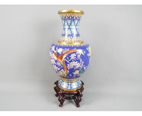 A large Chinese cloisonné vase decorated to the body with flowers, birds and insects against a blue ground, ruyi head band to