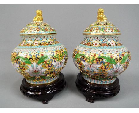 A pair of Chinese cloisonné covered vases with stylised floral decoration, ruyi head band to the shoulder and rim, the covers