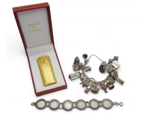 A Gold plated lighter, marked 'Le Must de Cartier', with original box, paperwork and guarantee, together with a Silver charm 