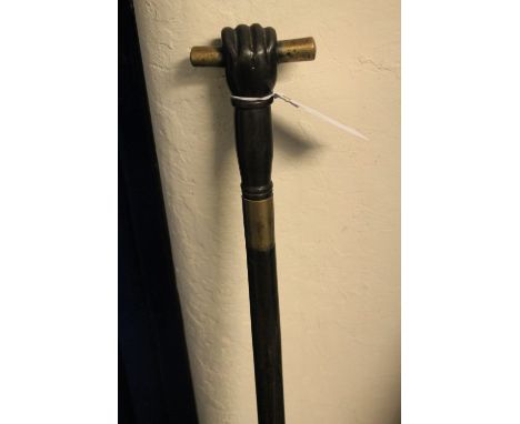 Heavy brass mounted hardwood walking stick, the handle formed as a clenched fist grasping a scroll.  CONDITION REPORT: Some w