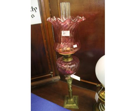 Brass double burner oil lamp with writhen cranberry glass reservoir on a brass corinthium column pedestal with square stepped