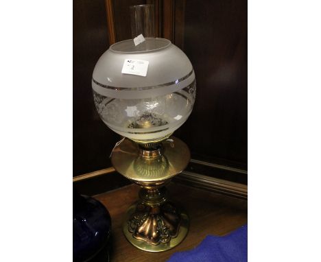 All brass double burner oil lamp with foliate embossed base and etched glass shade with clear chimney. 