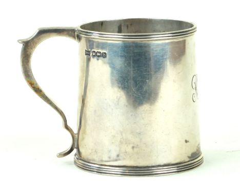 A George V silver mugOf tapered circular from, with applied reeded rims, to a scroll handle, monogrammed, by Walker & Hall, S