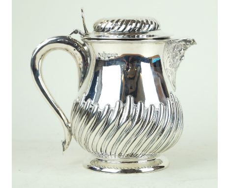 A Victorian silver jug with cast bacchanalian spout Of baluster form, with an embossed fluted lower body and hinged lid, the 