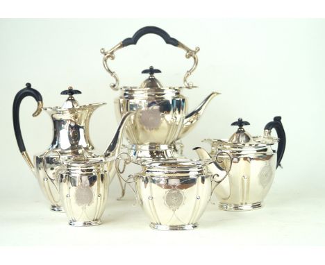 An Edwardian matched five piece silver tea serviceOf oval panelled and lobed form, centring an engraved foliate and scroll ca