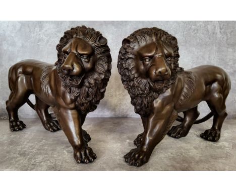 A pair of bronze lions 33cms x 24cms high 