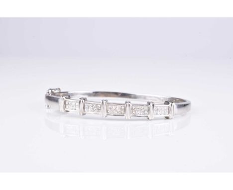A Princess cut diamond set hinged bangle, designed as five panels of eight Princess cut diamonds, channel set to white metal 
