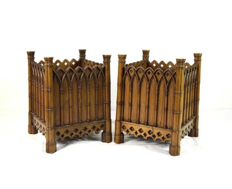 A pair of Gothic revival walnut jardinieresOf cuboid form, carved with arched architectural mouldings.54cm sq. x 71.5cm high 