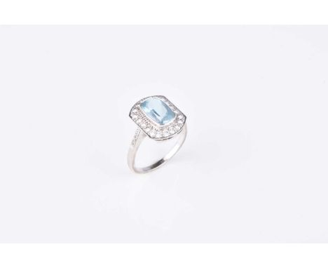 An 18ct white gold aquamarine and diamond cluster ring, designed as a central oval mixed cut aquamarine collet set within a b