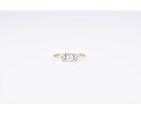 A graduated three stone diamond ring, the old cut diamonds claw set in white metal to yellow metal shank, ring size K, weight