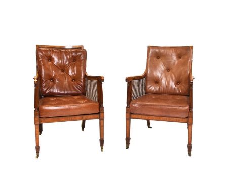 A pair of 19th century caned bergère library chairsWith drop-in leather back and seat cushions, the downswept arms with satin