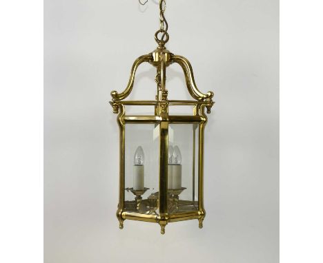 A reproduction brass lantern ceiling lightOf hexagonal form with bevelled glass to each side, fitted with a pendant triple la